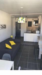 a living room with a couch and a kitchen at Superbe appartement sur quai centre ville in Sète