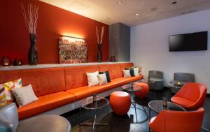 a lobby with an orange couch and orange chairs at Wyndham Garden Duesseldorf City Centre Koenigsallee in Düsseldorf