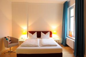 1 dormitorio con 1 cama, 1 silla y 1 ventana en Schlaflounge, en Hamburgo