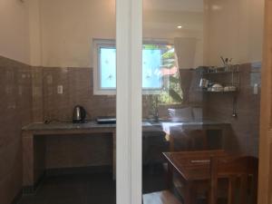 - une cuisine avec un comptoir et une fenêtre dans une pièce dans l'établissement Sun & Wind Paradise Bungalow, à Duong Dong