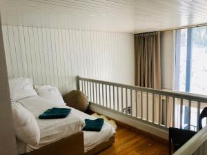 een slaapkamer met 2 bedden en een balkon met een raam bij Design loft in Chamonix Center in Chamonix-Mont-Blanc