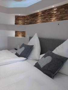 a bedroom with two white beds with pillows at Apartmenthaus am Tegernsee - Studios mit Küchenzeile und mit Bus erreichbar in Bad Wiessee