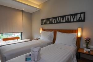 Ένα ή περισσότερα κρεβάτια σε δωμάτιο στο BATIQA Hotel Lampung