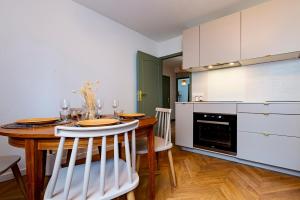 a kitchen with a wooden table with chairs and a dining room at Le Jouvence Cozy - Confort - Zen - Parking gratuit in Dijon