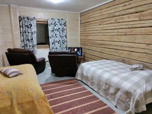 1 dormitorio con 1 cama y 2 sillas en Guesthouse Pekkala, en Rovaniemi