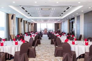 Gwangyang Lacky Hotel في Gwangyang: قاعة احتفالات مع طاولات وكراسي بمناديل حمراء