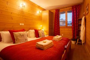 una camera da letto con due letti con asciugamani sopra di Chalet Rosko by Chalet Chardons a Tignes