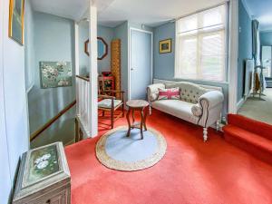 uma sala de estar com um sofá e um tapete vermelho em Quince Cottage em Saint Michaels