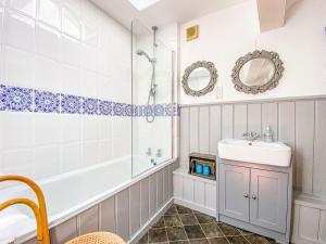 uma casa de banho com uma banheira, um lavatório e um chuveiro em Quince Cottage em Saint Michaels