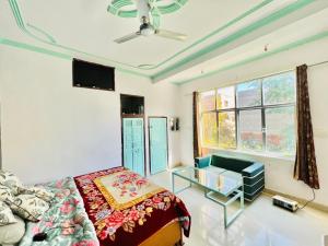 a bedroom with a bed and a tv and a window at Bhoora House in Jaipur