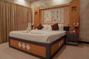 a bedroom with a large bed in a room at Seasons Suites JP Nagar in Bangalore