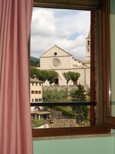 una finestra con vista su una chiesa di Camere Santa Chiara ad Assisi