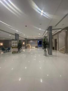 a large lobby with white floors and potted plants at قولد تاور in Khamis Mushayt