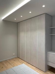 a room with gray cabinets and a white wall at A10 Palazzo Marconi Apartment in San Giovanni Valdarno