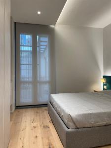 um quarto com uma cama e uma porta de vidro deslizante em A10 Palazzo Marconi Apartment em San Giovanni Valdarno