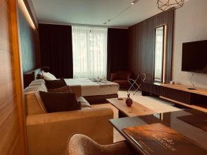 a hotel room with a bed and a couch at Woodside Apartman Kopaonik 315 in Kopaonik