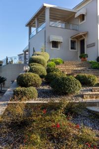 Una casa con arbustos y escaleras delante. en VILLA SORELLINA, en Gouvia