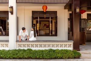 a bride and groom standing on the front of a building at Wyndham Garden Hoi An Cua Dai Beach in Hoi An