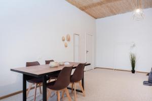 een eetkamer met een houten tafel en stoelen bij Bali house Vilnius in Vilnius