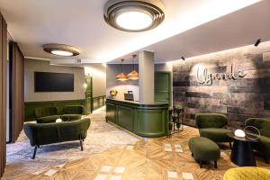 奥泰佩Ugandi Hotel的一间设有绿色椅子和柜台的等候室