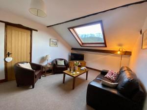 a living room with leather furniture and a skylight at Seven Stars Inn in Builth Wells