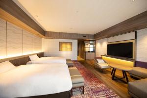 a hotel room with two beds and a flat screen tv at Beppu SUGINOI HOTEL in Beppu +70 photos