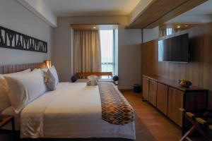 Ένα ή περισσότερα κρεβάτια σε δωμάτιο στο BATIQA Hotel Lampung