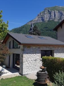 a stone house with a mountain in the background at Maison Milla in Saint-Égrève