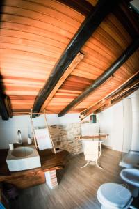 baño con techo de madera, lavabo y aseos en Cascina Boschetto, en Saliceto