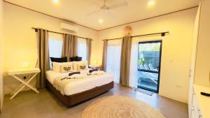 1 dormitorio con cama y ventana grande en Inave Oasis 3 Bedroom Villa "Your home away from Home" en Arorangi