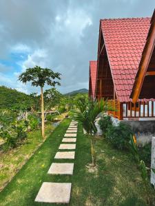 einen Weg zu einem Haus mit rotem Dach in der Unterkunft dbelish village & resto in batumadeg