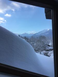 a snow covered window with a view of a mountain at Ferienwohnung Baldauf in Oberstdorf