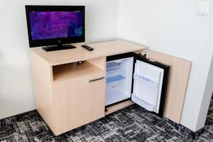 einen Schreibtisch mit einem TV und einem Kühlschrank in der Unterkunft Centralny Ośrodek Sportu - Zakopane in Zakopane