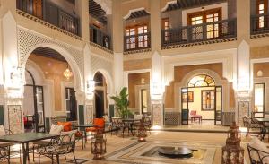 a lobby with tables and chairs in a building at DAR LYS in Fès