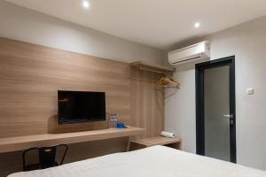 pokój hotelowy z łóżkiem i telewizorem oraz pokój w obiekcie TwoSpaces Living at Pakis Residence w mieście Wonokitri 2