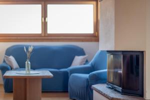 uma sala de estar com um sofá azul e uma mesa em Weinberghof em Termeno