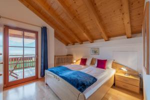 a bedroom with a bed and a large window at Weinberghof in Termeno