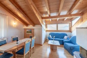 a living room with a table and a blue couch at Weinberghof in Termeno