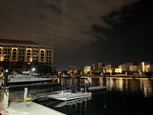 a boat docked at a dock in the water at night at Fabulous 1BHK Jadaf Water Front Near Metro Station in Dubai