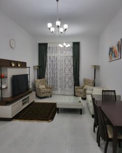 a living room with a couch and a tv at Fabulous 1BHK Jadaf Water Front Near Metro Station in Dubai
