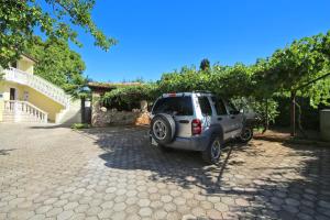 una pequeña camioneta estacionada en una entrada junto a una casa en Barbic, en Medulin