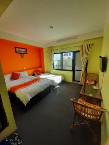 a hotel room with two beds and a window at Hotel Sunrise View in Nagarkot
