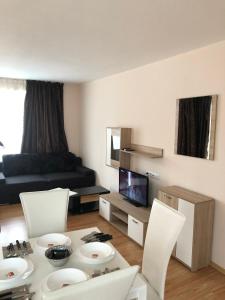 ein Wohnzimmer mit einem Tisch, Stühlen und einem Sofa in der Unterkunft Palace De Luxe - Apartments in Pomorie