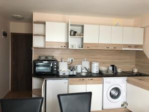 a kitchen with a microwave and a washing machine at Palace De Luxe - Apartments in Pomorie