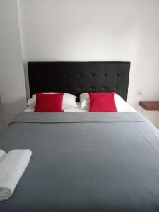 a large bed with two red pillows on it at Guest House d Valeri in Labuan Bajo