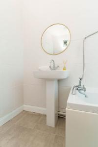 a white bathroom with a sink and a mirror at St Johns House in Leeds