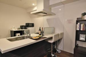 een keuken met een wit aanrecht en een wastafel bij 書斎でくつろぐスイートルーム in Nagoya