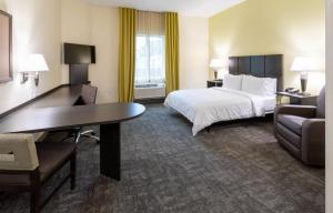 a hotel room with a bed and a desk at Candlewood Suites - Rochester Mayo Clinic Area in Rochester