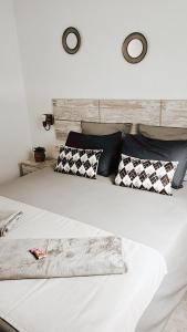duże białe łóżko z czarno-białymi poduszkami w obiekcie Villa Mia w mieście Tuineje