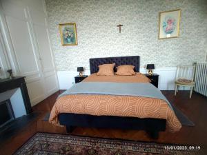 a bedroom with a bed with a cross on the wall at Fief des 3 Guillaume Chambres d'hôtes in Écouis